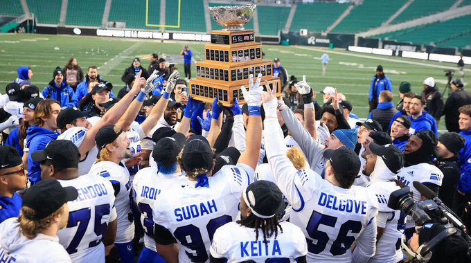a football team hoists the championship trophy
