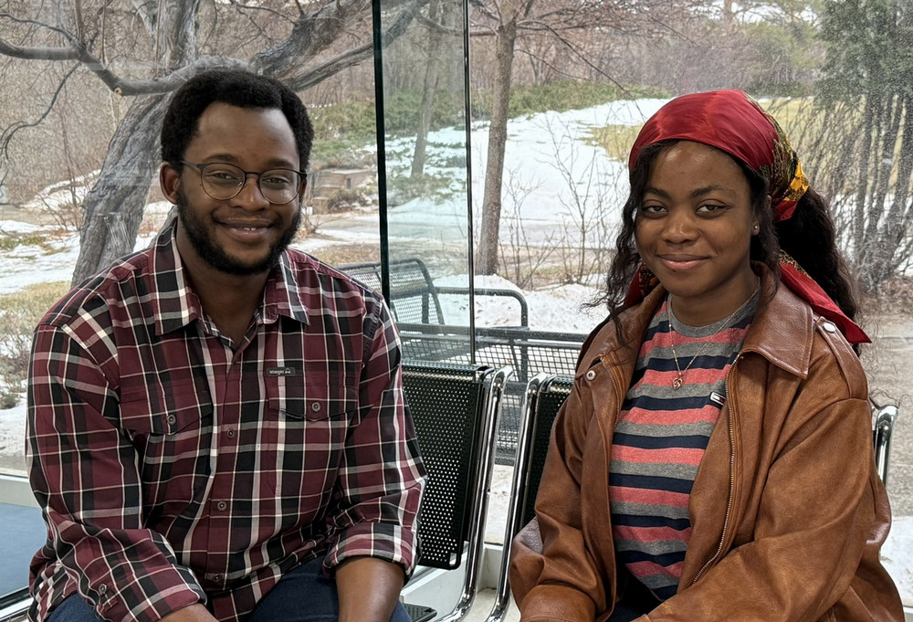 Two people sitting facing camera.