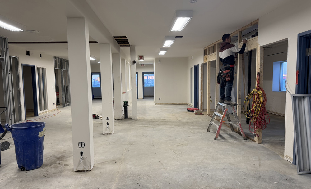 A lone worker does construction in a half-finished space