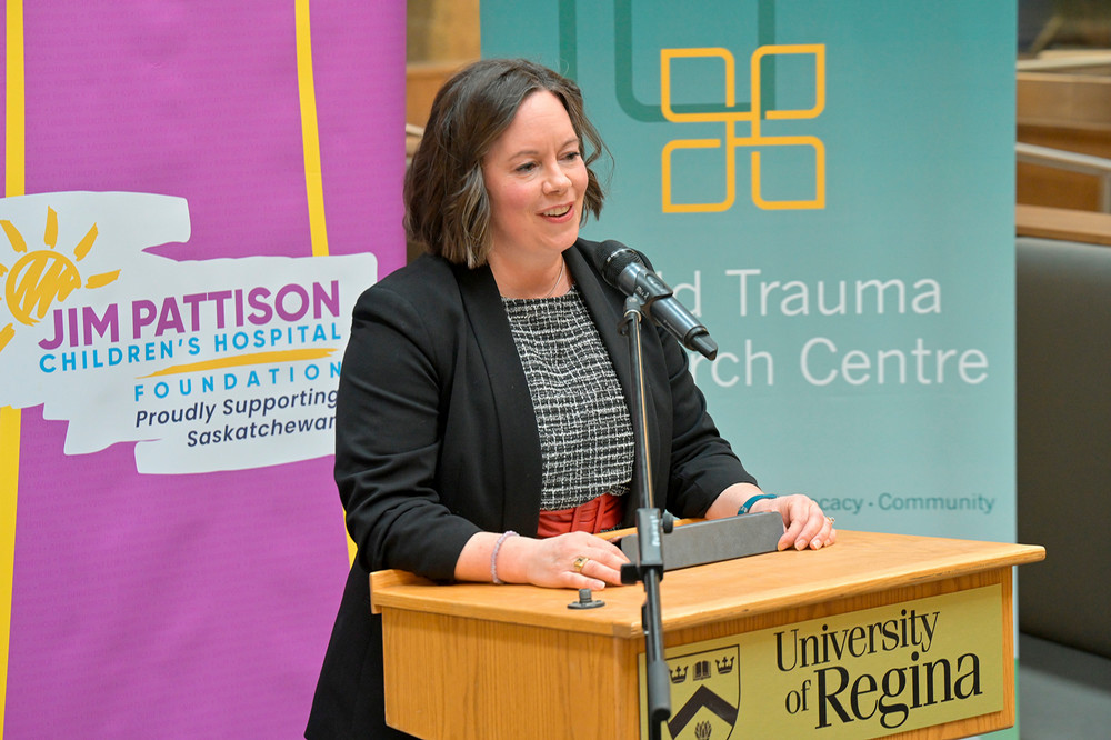 Woman stands at podium.