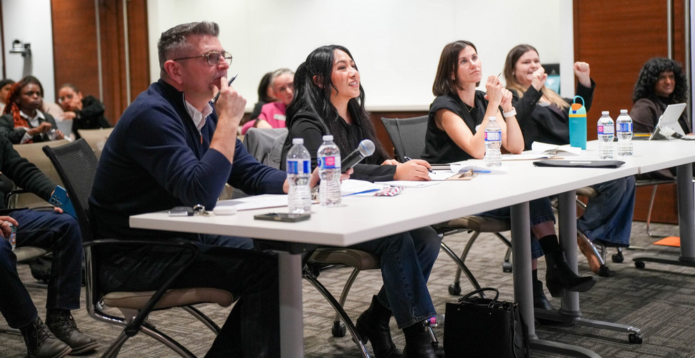 A panel of three judges observes student presentations 