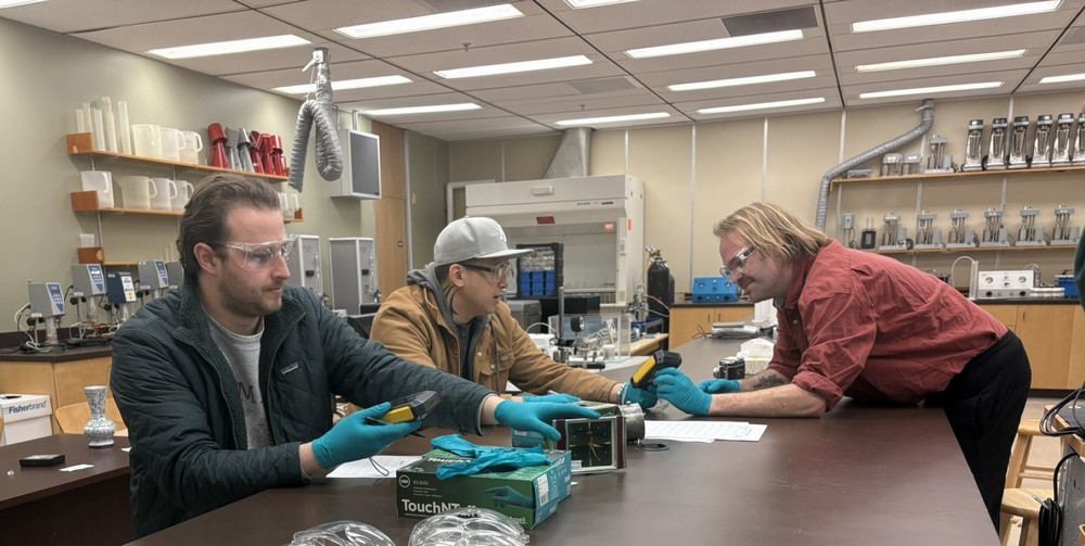Individuals gathered around a table in a lab.