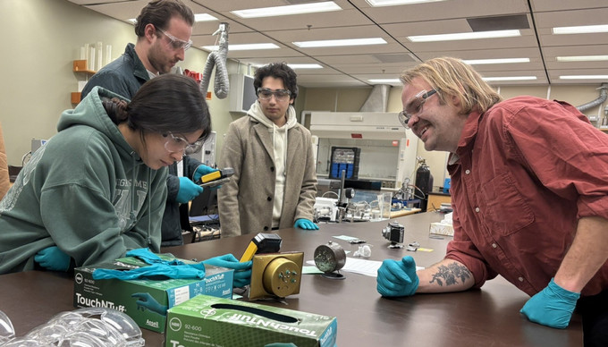 Individuals gathered around a table in a lab