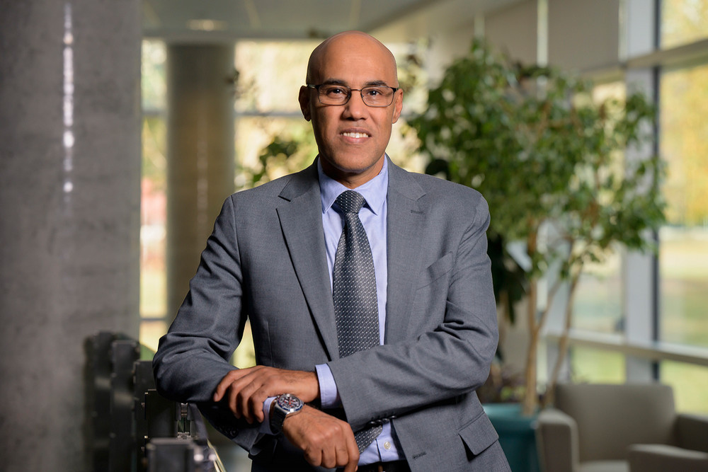 A portrait photo of a man in a suit in a scenic indoor location