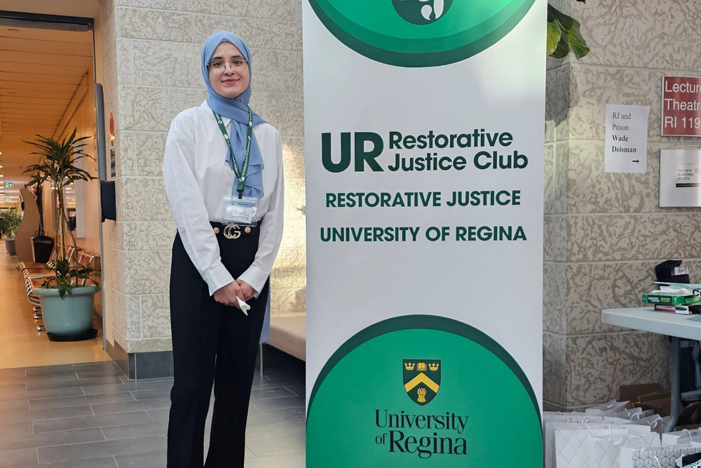 a smiling woman standing in a hallway