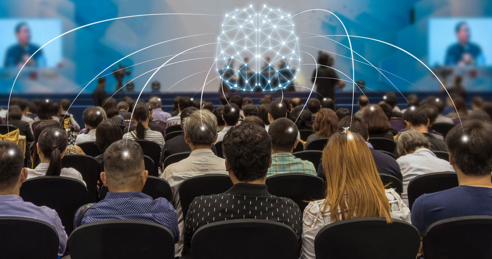 A glowing digital AI brain hovers above a conference crowd, with illuminated lines connecting directly into attendees' heads—symbolizing AI's invisible influence on human perception and information sharing