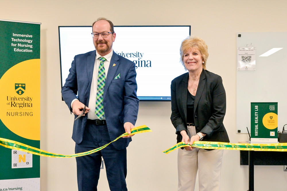 A man and a woman cutting a ribbon during a ceremony