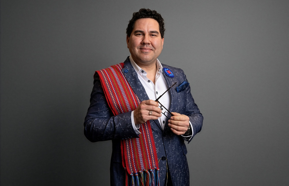 man wearing a sash and holding his glasses