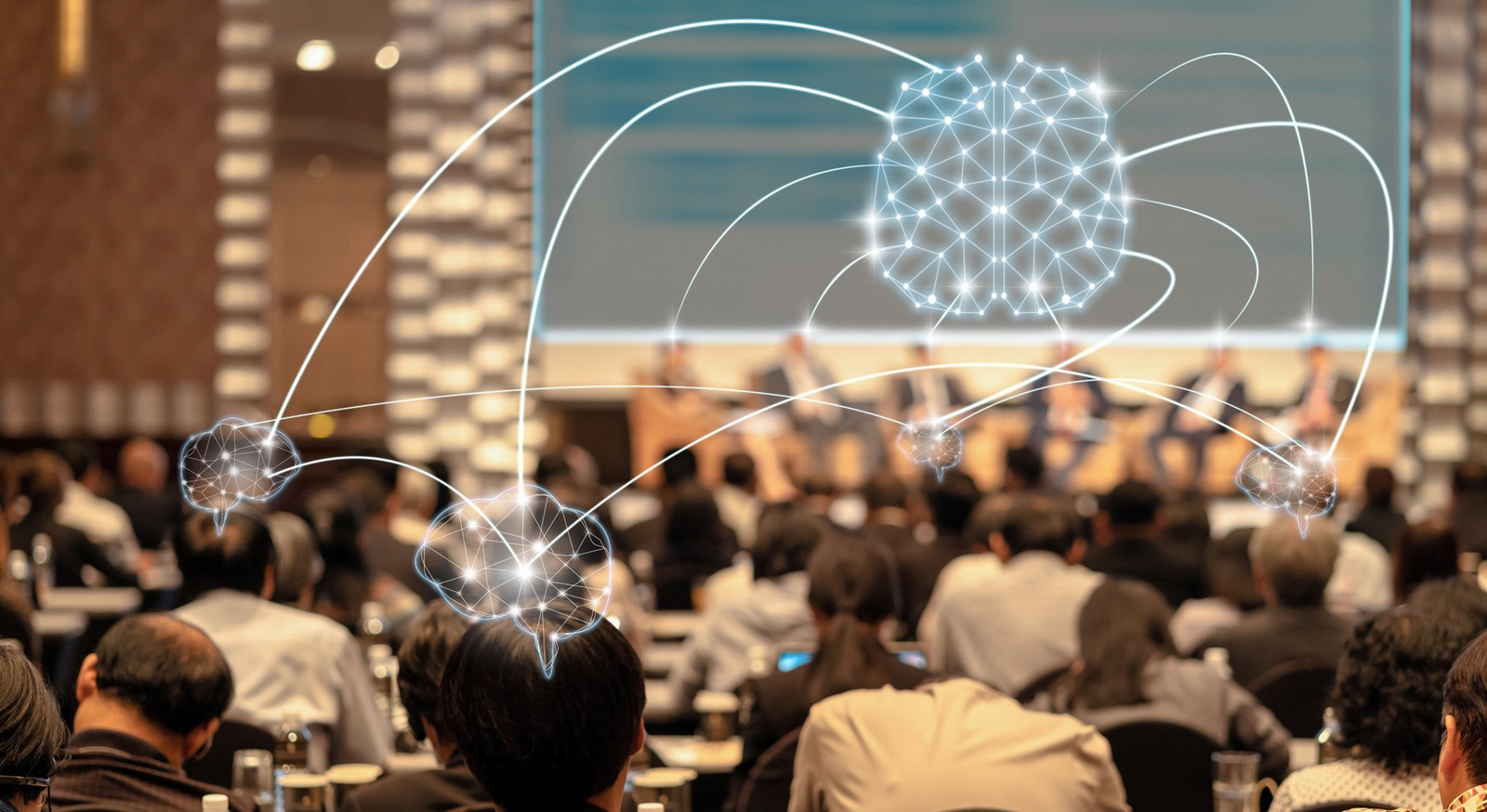 A wide conference-style image showing people gathered in conversation around digital AI visuals, representing community participation in decisions about artificial intelligence