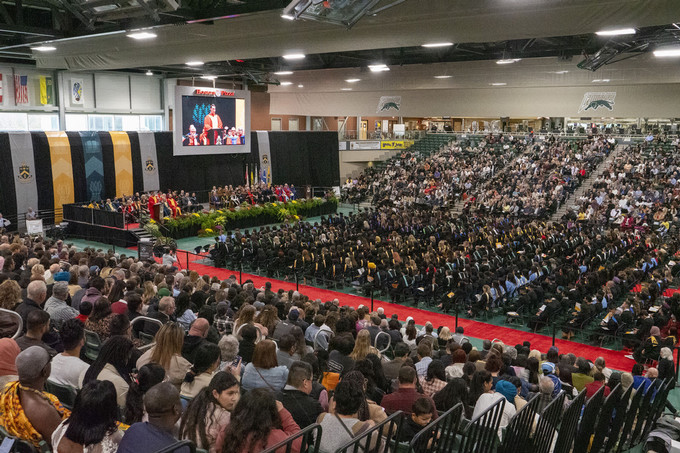 a crowd of graduates in a gymnasium