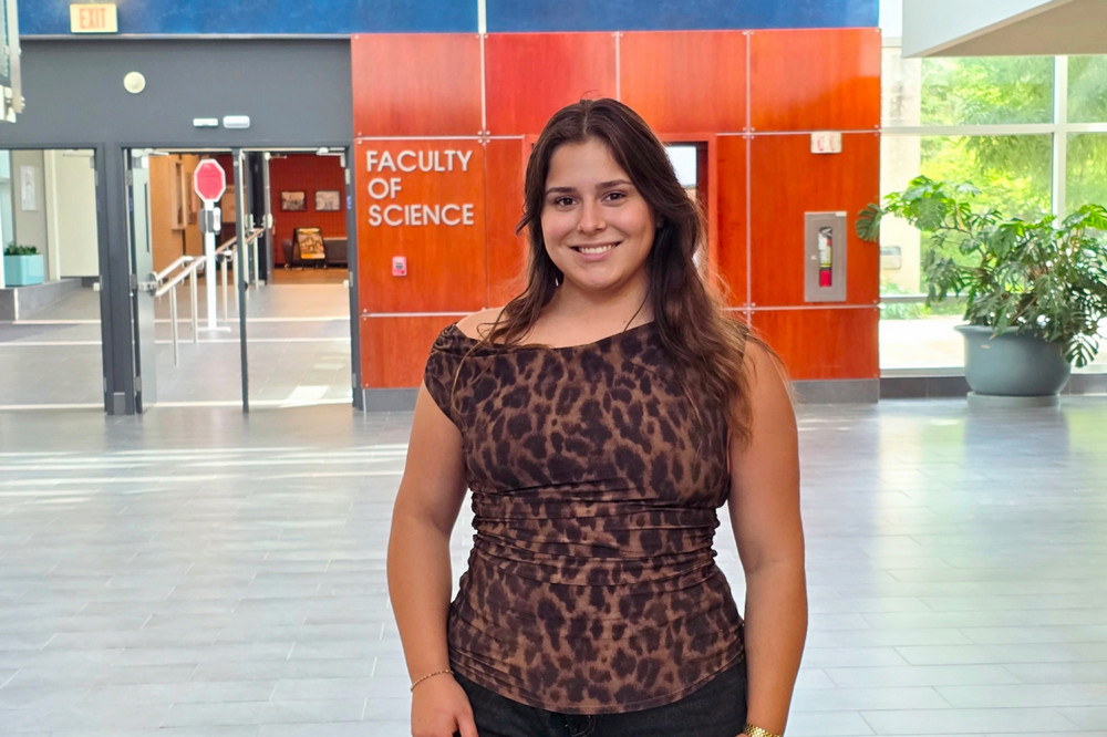 Avery Horvath, a 4th year Psychology student in the Faculty of Arts, smiles in a bright campus atrium at the University of Regina.