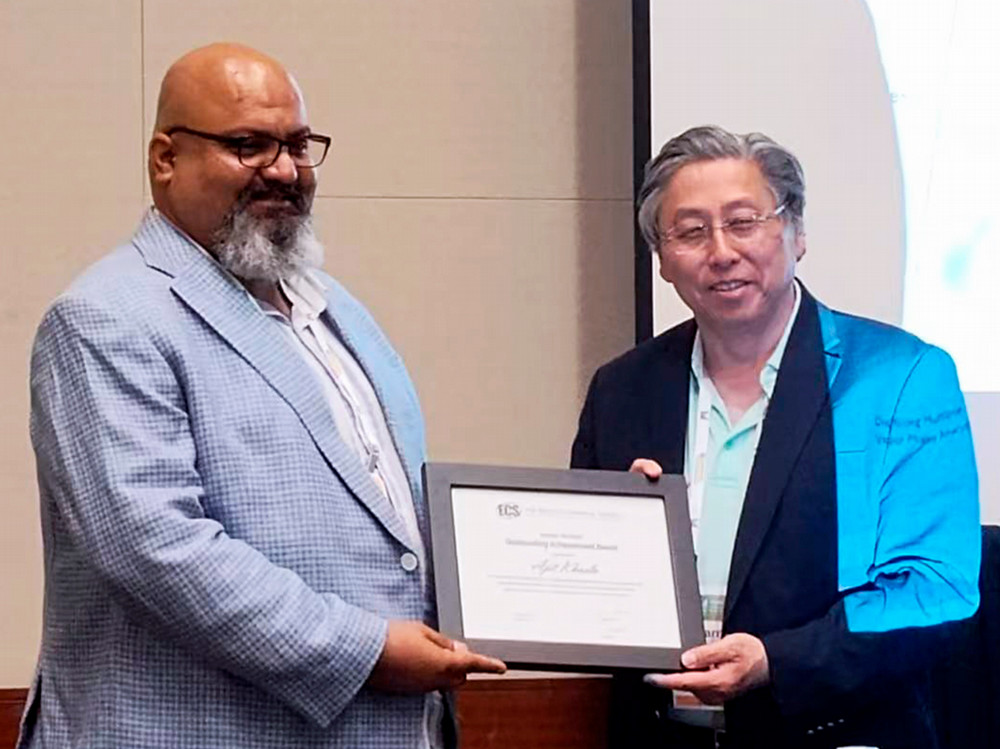 A man receiving an award from another man