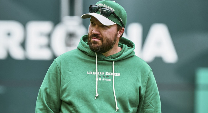 a man searing a green shirt and hat
