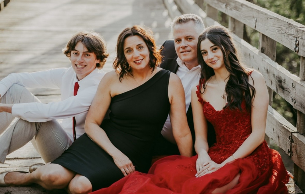 four people posing in formal wear