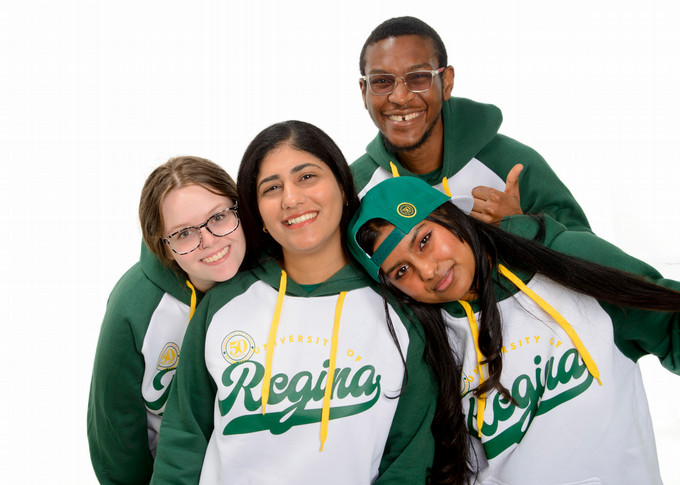 four people posing in U of R merchandise