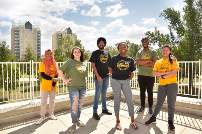 a group of six students outside on campus