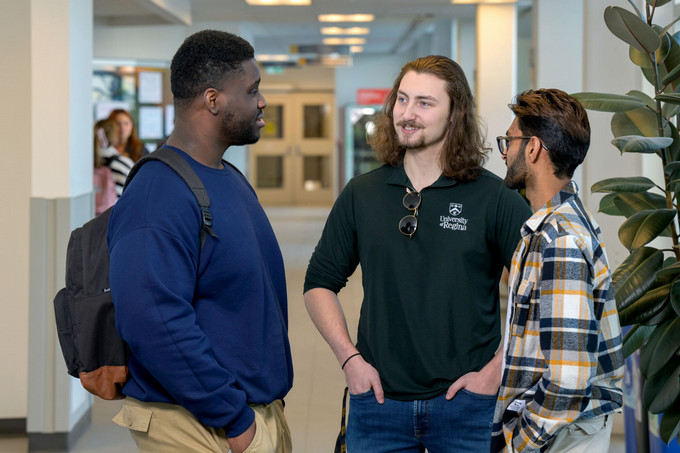 three students in standing in a hallway