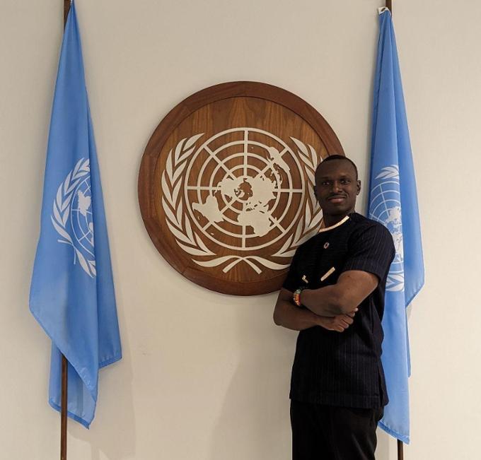 Student posing in front of United Nations logo
