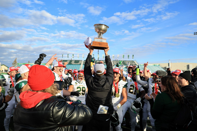 a group of people celebrating and holding up a trophy