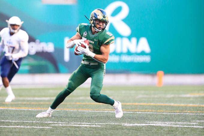 Rams football player running with the football down the field.