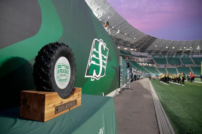 The U Prairie Challenge trophy, which is a small tractor tire mounted on polished wood.