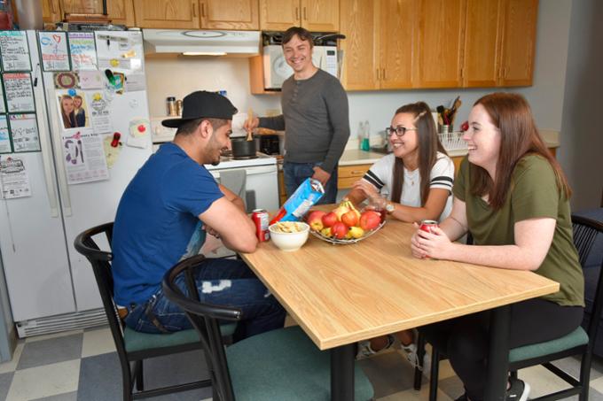 Students sitting around kitchen table in residence