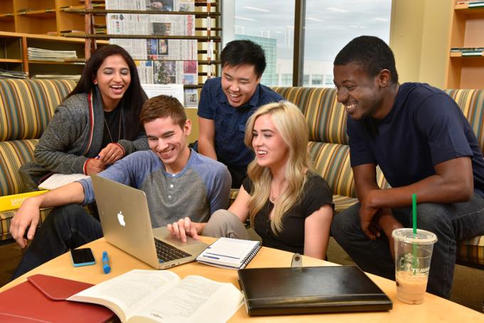 Students sitting around a laptop