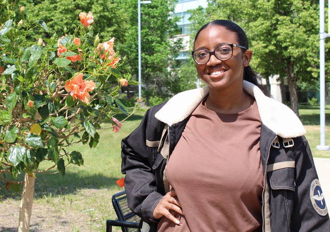Girl standing outside smiling.