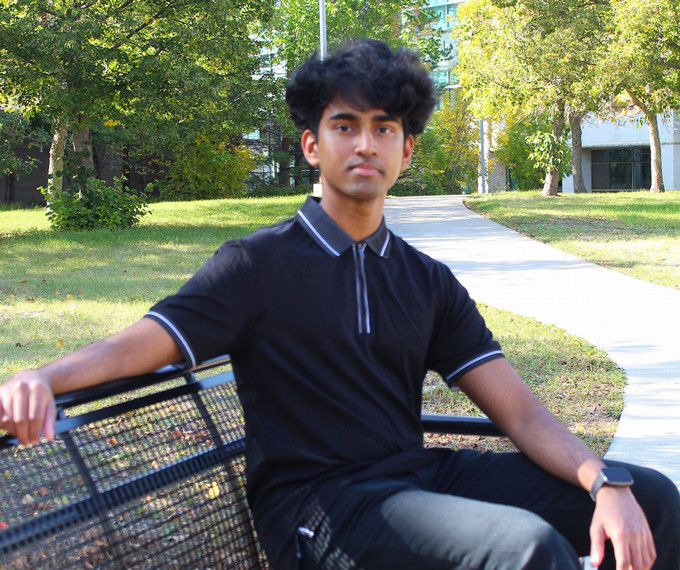 Boy sitting on bench.