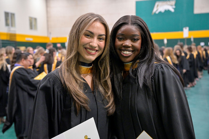 Two girls smiling at convocation.