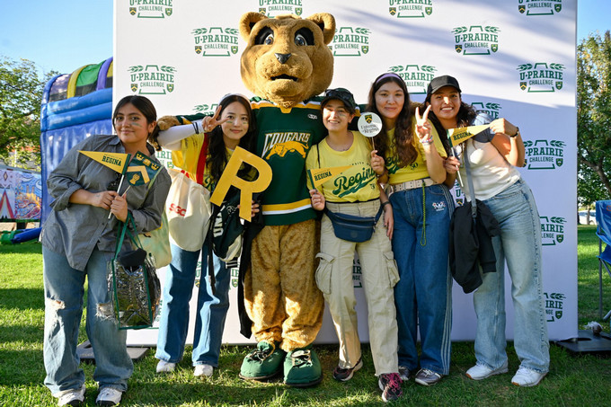 Students smiling with mascot.