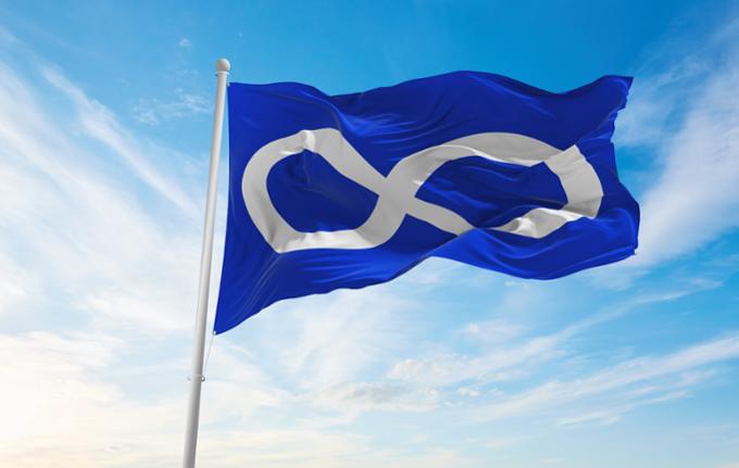 The Metis Nation flag flapping in the wind on a sunny day