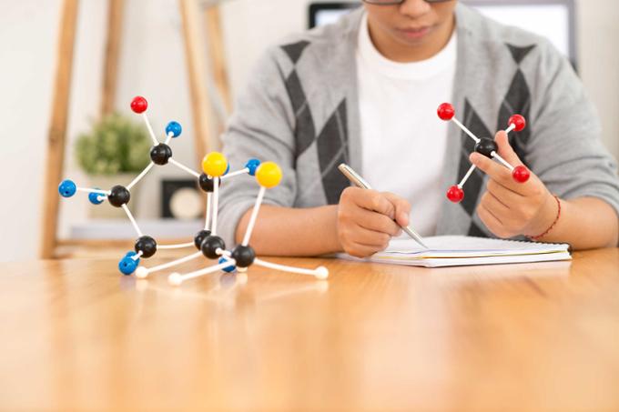 A man tinkers with a toy that looks like a molecule