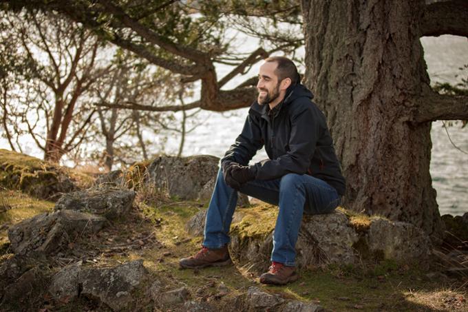 Microbiologist Andrew Cameron sitting under a tree