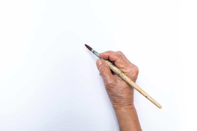 Image of a hand holding a paintbrush