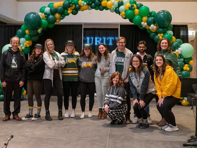 U of R students pose under a balloon arch